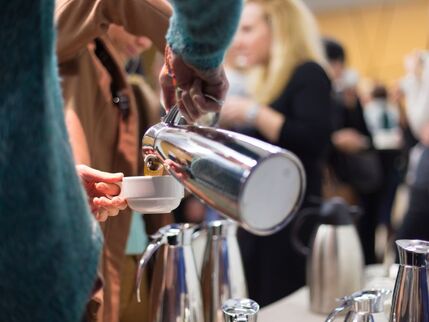 People pouring hot drinks from canisters 