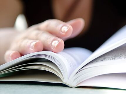 Womans hand turning pages of a book